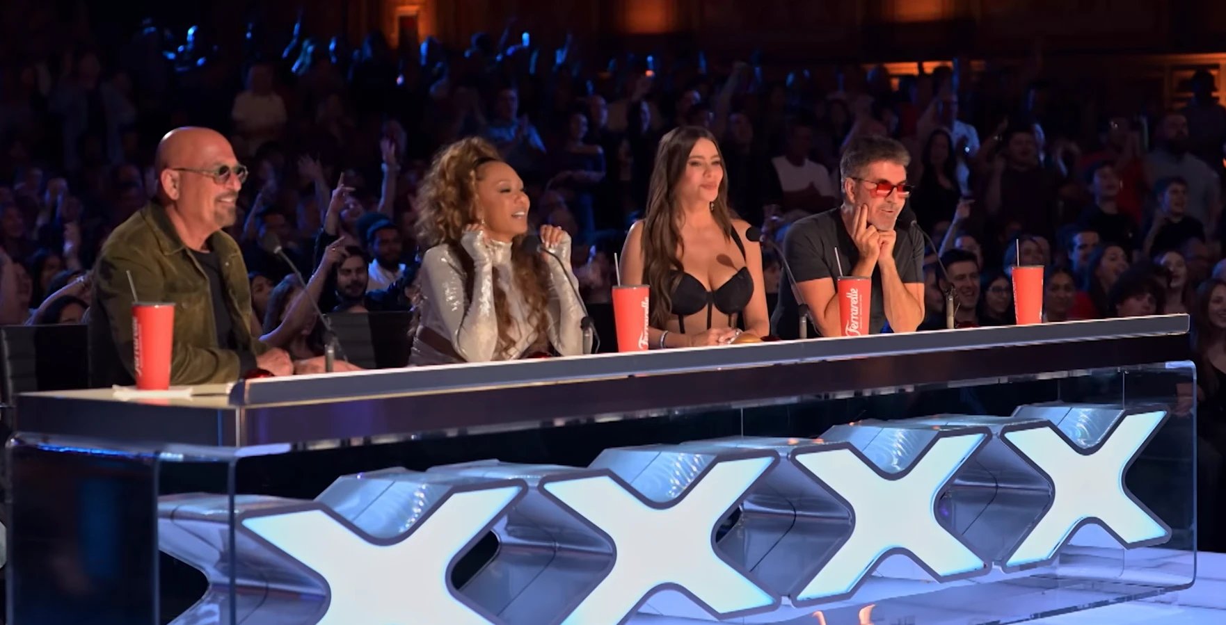 All four AGT judges — Howie Mandel, Mel B, Sofia Vergara, and Simon Cowell — smiling and reacting with delight at Nene Royal's performance, full audience visible behind them